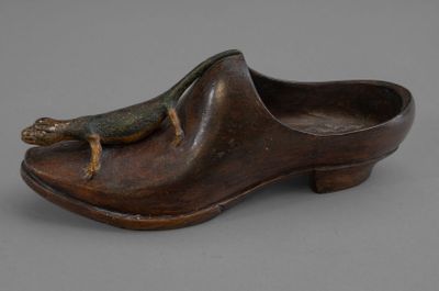 un vieux sabot en bois sur lequel est perché un lézard