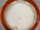 a red and white bowl with a brown rim