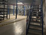 a picture of a large warehouse with lots of shelves and ladders