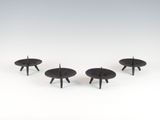trois petites tables noires placées les unes à côté des autres sur une surface blanche