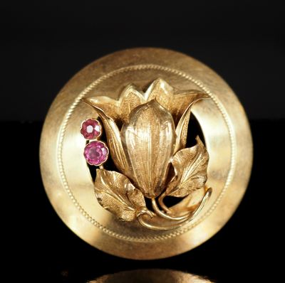 une image montrant un gros plan d'une broche en or ornée d'une fleur