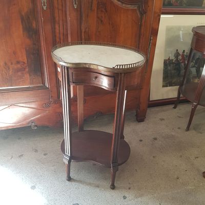 une petite table avec un plateau en marbre dans une pièce