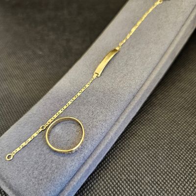 un gros plan d'un bracelet en or sur lequel est enfilée une bague