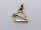 a close up of a gold pendant with a hammer on it