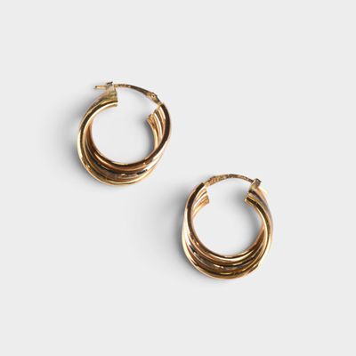 une paire de boucles d'oreilles en or sur fond blanc