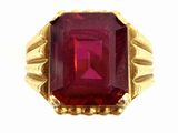 a close up of a ring with a red stone in it