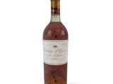 une vieille bouteille de vin posée sur une surface blanche