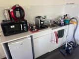 a small kitchen with a microwave, dishwasher, and other appliances
