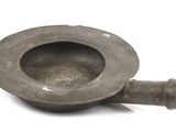 a small metal bowl that is sitting on a white surface