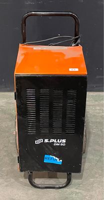 un radiateur portable orange et noir posé sur un sol en béton