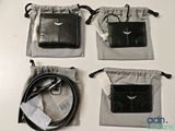 three black leather wallets are sitting on top of a white table