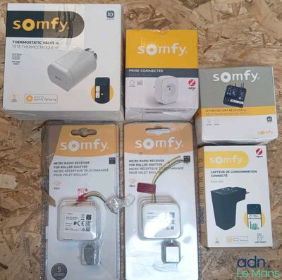 trois boîtes d'adaptateurs secteur Sony posées sur un parquet