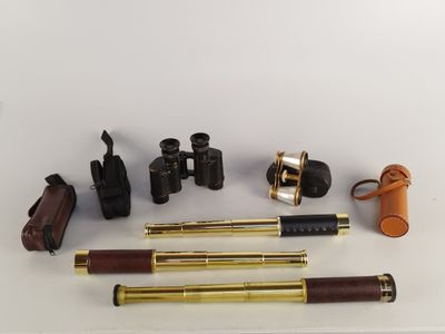 plusieurs types de télescopes et d'autres objets posés sur une surface blanche