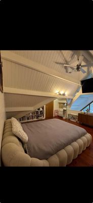 a large bed in the middle of a room with a flat screen tv on the wall