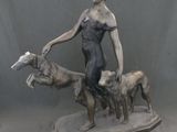 statue représentant une femme avec deux chiens et un chat sur un plateau