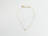 un collier en or avec un petit diamant suspendu à une chaîne