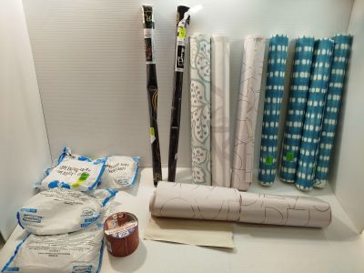 de nombreux rouleaux de tissu posés sur une étagère dans une pièce