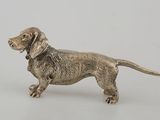 an antique silver dog figurine on a white background