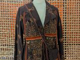 jacket on a mannequin stand in front of a woven wall