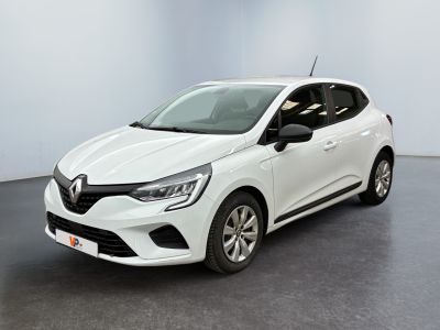 Une voiture blanche est garée dans une pièce au sol noir.