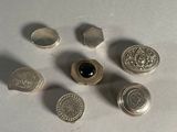 six silver buttons with a black stone sitting on a white surface