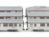 two model trains sitting side by side on a white surface