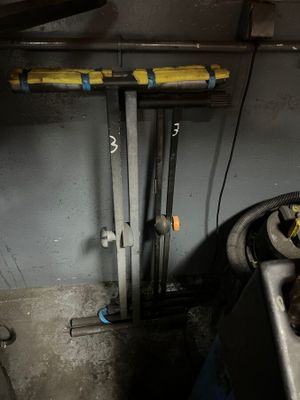 un évier dans une pièce sale, avec des tuyaux et un robinet