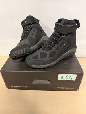 une paire de chaussures aquatiques noires posée sur une boîte