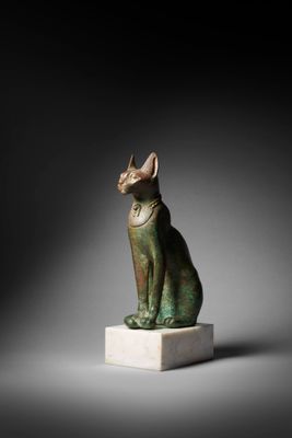 an egyptian bronze statue of a cat on a marble base
