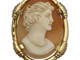 une image représentant le profil d'une femme sur une broche en or