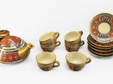 un service à thé comprenant une théière, des tasses et des soucoupes