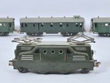 quatre petits trains miniatures posés sur une surface blanche
