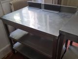 une table sur laquelle est posé un ordinateur portable, dans une pièce