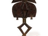 an image of a wooden sculpture of a bird on a stand