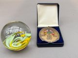 une petite boule de verre contenant une médaille