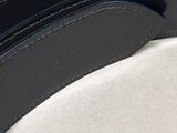 a close up of a black belt on a white surface