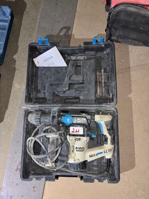un outil dans une mallette posée par terre à côté d'une valise
