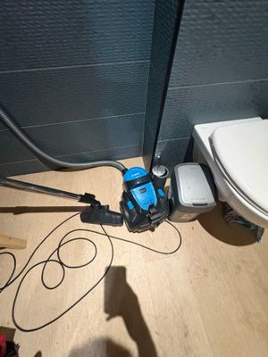 a toilet with a hose attached to it in a bathroom
