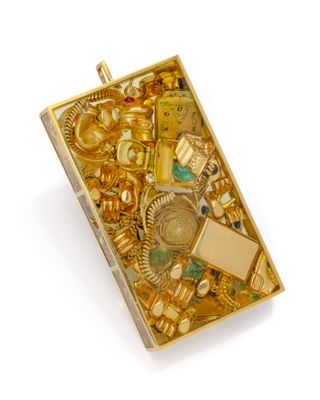 une boîte de bijoux en or posée sur une surface blanche