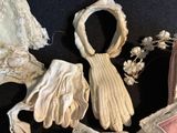 Plusieurs vêtements et des gants sont disposés sur une surface noire