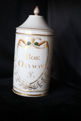 un bidon blanc avec une inscription dorée sur fond noir