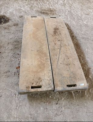 deux morceaux de bois posés par terre, dans la terre