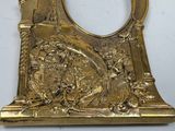 a gold clock with a picture of a man and woman on it