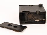 an old camera and a small device on a white surface
