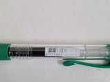 a green pen sitting on top of a white table next to a green marker