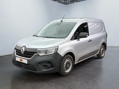 La camionnette argentée est garée dans une pièce blanche au sol noir.