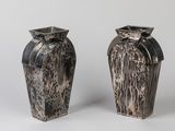 two vases that are sitting side by side on a white surface
