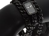 a black watch on a black bracelet on a mannequin arm