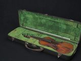 a violin in a green case on a black background