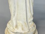 an antique statue of a woman holding a baby in her arms